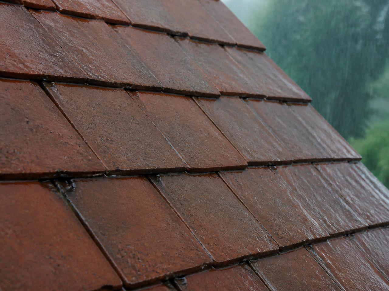 Tuiles poreuses sous la pluie : l'eau pénètre et fonce le matériau avant traitement